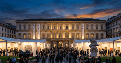 Crowd at MIART art fair with illuminated historic building at sunset