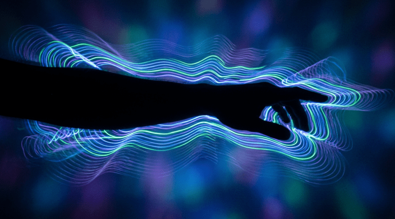 Silhouette of a hand with swirling neon blue, purple, and green light waves around it