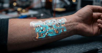 Electronic circuit patch with glowing blue and orange lights on forearm
