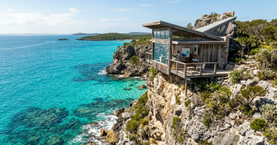 Artist working inside a wooden studio on a cliff with ocean view