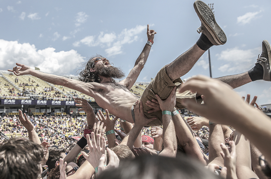 Punk rock fans crowd-surfing and moshing enthusiastically at a festival concert