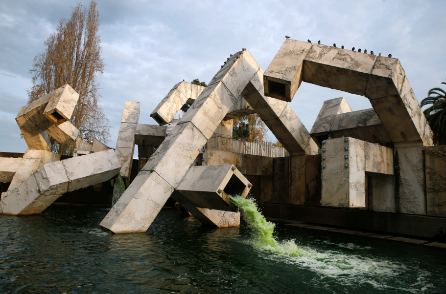Historic view of the Vaillancourt Fountain at Embarcadero Plaza, San Francisco, showing its large concrete forms with cascading water and birds perched on the structure before dismantling.


