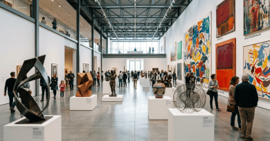 Large modern art gallery with sculptures on white pedestals and colorful abstract paintings on walls, people walking and observing art