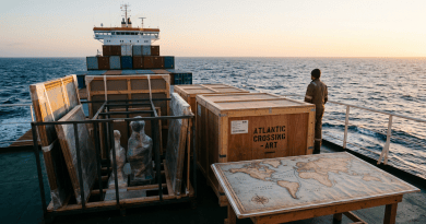 Crated sculptures, framed artworks, and a wooden crate labeled Atlantic Crossing Art on cargo ship deck at sea