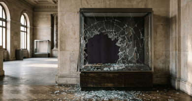 Shattered glass display case in an empty museum hallway