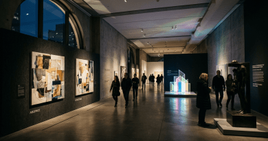 Visitors viewing paintings, sculpture, and a glowing geometric installation in a museum gallery