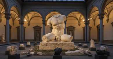 A fragmented classical sculpture stands in a Renaissance palazzo courtyard under warm museum light.